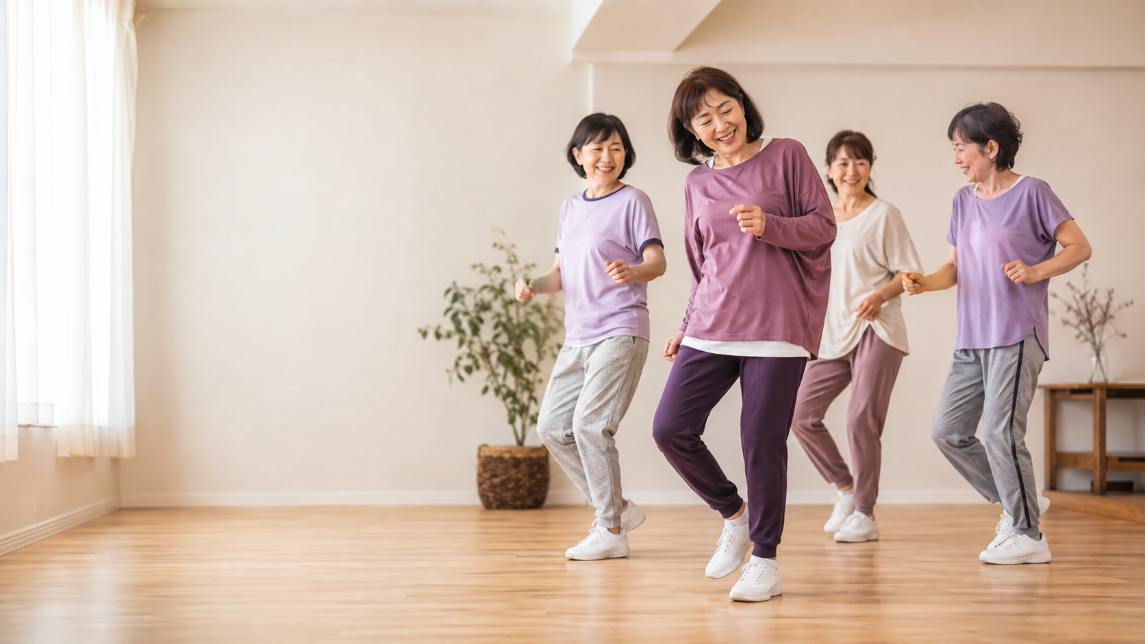 明るいダンススタジオで、50代の女性たちが笑顔でダンスを楽しむ様子。初心者同士で安心して一歩を踏み出せる、温かい雰囲気を表現しています。